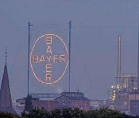Nachtaufnahme des beleuchteten Bayer-Kreuzes in Leverkusen
